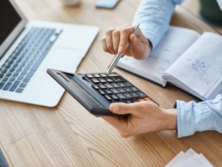 Plano medio de unas manos sujetando una calculadora representando el calculo del CAC Payback Period.