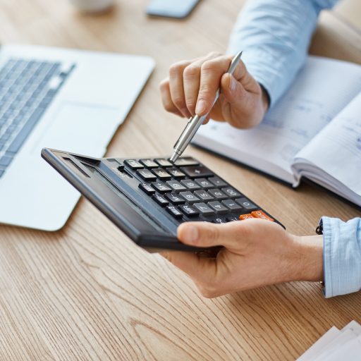Plano medio de unas manos sujetando una calculadora representando el calculo del CAC Payback Period.